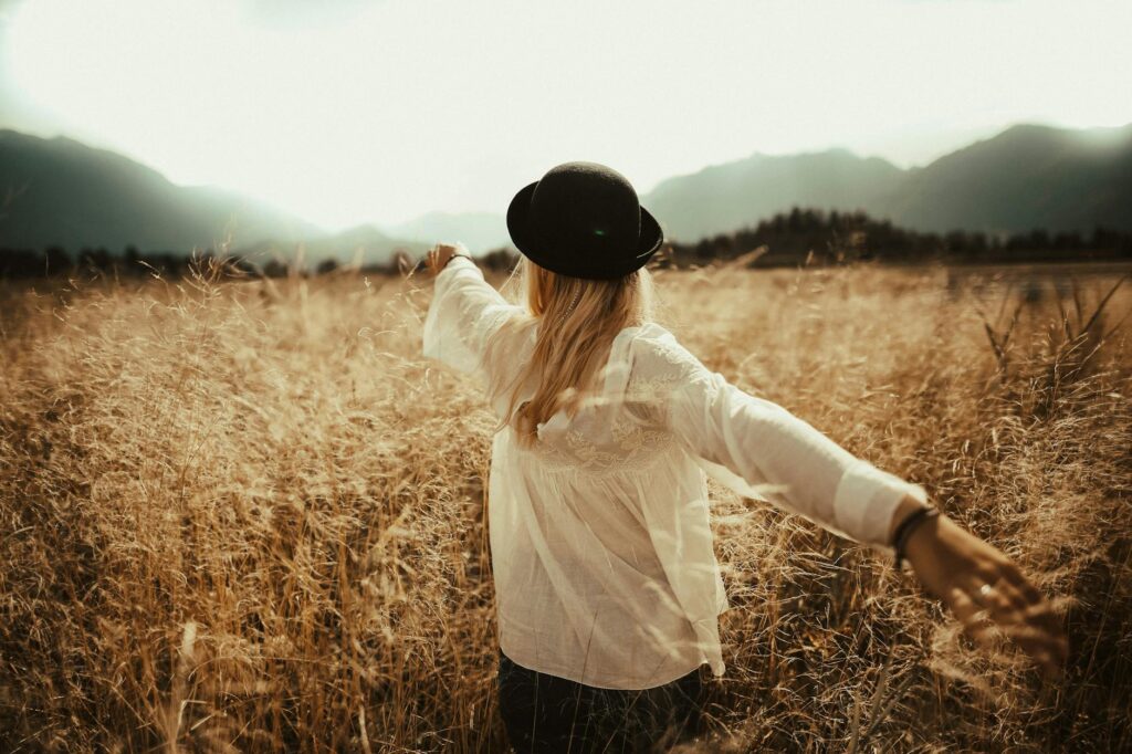 woman walking on brown grass field